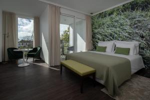 a hotel room with a bed and a table and chairs at Senhora da Rosa, Tradition & Nature Hotel in Ponta Delgada