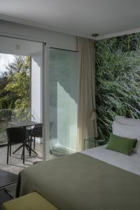 a bedroom with a bed and a sliding glass door at Senhora da Rosa, Tradition & Nature Hotel in Ponta Delgada