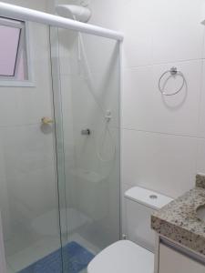 ein Badezimmer mit Dusche, Toilette und Waschbecken in der Unterkunft Ótimo Apartamento Ubatuba in Ubatuba