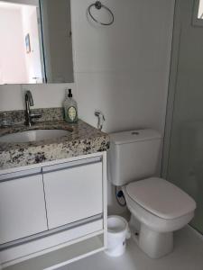 ein Badezimmer mit einer weißen Toilette und einem Waschbecken in der Unterkunft Ótimo Apartamento Ubatuba in Ubatuba + 9 Fotos