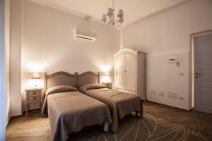 a bedroom with two beds and a chandelier at City Garden Guest House in Olbia