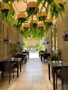 um restaurante com mesas, cadeiras e plantas em Hotel Catena em Cochabamba