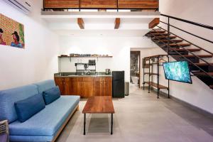 a living room with a blue couch and a staircase at NATURA Loft Garden in Santa Teresa Beach