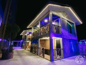 a house with purple lights on the side of it at Mangrove Floating Chalet in Kukup