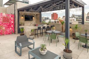 un patio con mesas y sillas y un bar en Felix Luxury Plus by Viadora en Ciudad de México