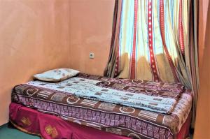a small bed in a room with a window at Villa Orange Lembang Pengkolan in Lembang +31 photos