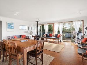 a living room with a wooden table and chairs at Spacious Adventure Getaway by the Bush & Ocean in Macmasters Beach