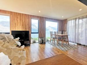 a living room with a table and chairs and a television at Lakeview Unit in Queenstown