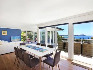 a dining room with a table and chairs and a large window at Enjoy Spectacular Oceanviews with BBQ & Airy Space in Terrigal