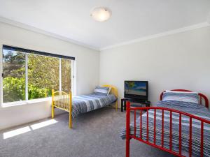 a bedroom with two beds and a window at Enjoy Spectacular Oceanviews with BBQ & Airy Space in Terrigal