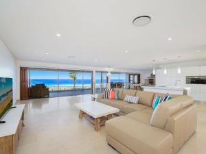 a living room with a couch and a table at Amazing Seaviews and Beachfront Leisurely Home in The Entrance