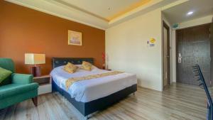 um quarto com uma cama e uma cadeira verde em Plearnwan Deluxe Mansion em Bangkok