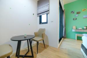 a room with a table and a chair and a bed at 鴻滿億民宿 in Magong