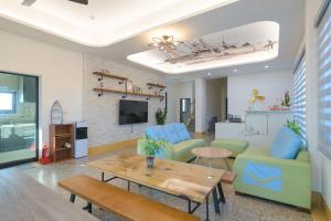a living room with blue chairs and a table at 鴻滿億民宿 in Magong