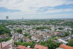 an aerial view of a city with houses and trees at Comfy 2BR Apartment at Parkland Avenue By Travelio in Babakan