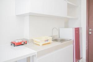 a kitchen counter with a sink and a appliance on it at Comfy 2BR Apartment at Parkland Avenue By Travelio in Babakan