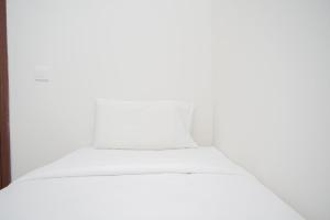 a stack of white beds in a room at Comfy 2BR Apartment at Parkland Avenue By Travelio in Babakan +14 photos