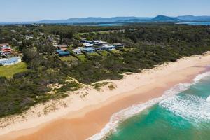 an aerial view of a beach with houses and the ocean at Culburra Beachhouse in Greenwell Point