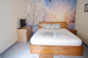1 dormitorio con 1 cama y una pintura en la pared en Winter Spring Homestay, en Can Tho