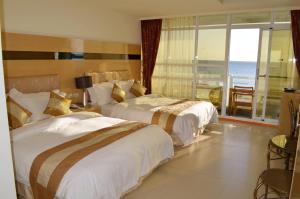 2 camas en una habitación de hotel con vistas al océano en Yake Homestay, en Eluan