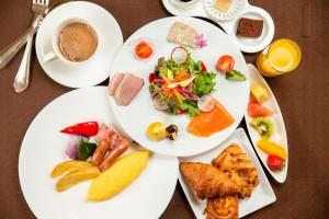 dois pratos brancos de comida numa mesa em Hotel Monterey Edelhof Sapporo em Sapporo