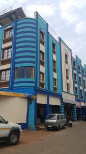 a blue building with cars parked in front of it at HOTEL AVISHA Residency in Marmagao