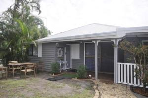 uma casa com uma mesa e um pátio em Island Bungalow em Bongaree