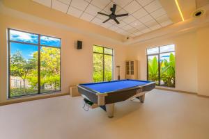 a pool table in a room with windows at Club Mahindra Assonora in Assonora