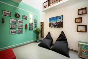 a living room with black pillows on a wall at StayVista at Saanu Ki Villa with free Breakfast in Candolim