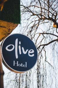 un cartello per questo hotel di fronte a un albero di Olive By Tej Hotel And Resorts a Darjeeling