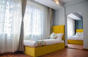 una camera con un letto giallo di fronte a una finestra di Olive By Tej Hotel And Resorts a Darjeeling