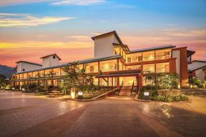 a large building with a sunset in the background at Club Mahindra Assonora in Assonora