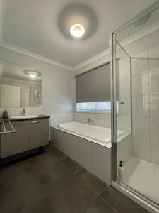 a white bathroom with a tub and a shower at 63 Grigg in Koondrook