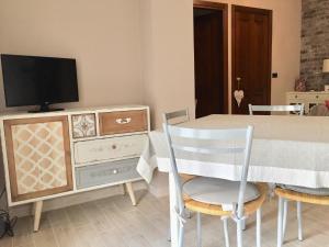 アルゲーロにあるCozy Apartment in Algheroのダイニングルーム(テーブル、ドレッサー内のテレビ付)