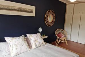 ein Schlafzimmer mit einem Bett und einem Stuhl in der Unterkunft Ducks Nest in Malelane