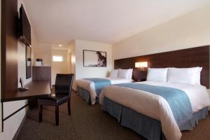Una habitación de hotel con dos camas y un escritorio. en Steam Plant Hotel, en Spokane
