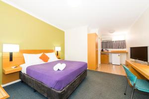 a hotel room with a bed, desk, and a television at ibis Styles Geraldton in Geraldton