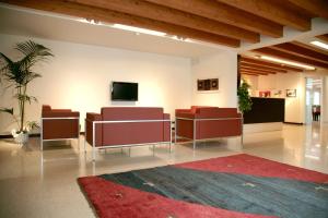 a lobby with chairs and a tv on a wall at Corte Della Rocca Bassa in Nogarole Rocca
