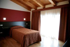 een slaapkamer met een bed en een groot raam bij Corte Della Rocca Bassa in Nogarole Rocca