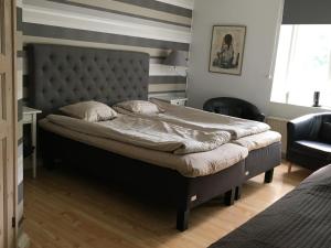 a bedroom with a large bed with a tufted headboard at Kvarnen i Borgvik in Borgvik