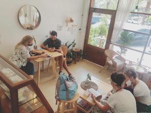 大城的住宿－Room Story Hostel，一群人坐在一个房间里桌子上