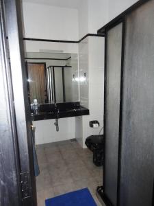a bathroom with a black toilet and a sink at Hotel Country Comfort in Ella