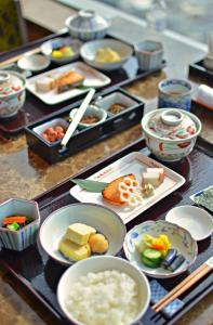 a table topped with plates of food and bowls of food at The Okura Prestige Bangkok in Bangkok