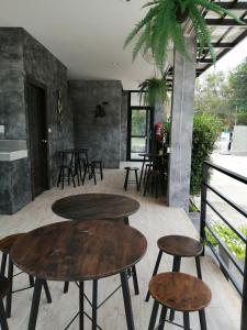Sangkhomにあるเคียงภูวิลล่าのテーブルと椅子付きの部屋内のテーブル2台とスツール
