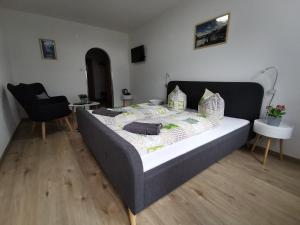 a bedroom with a bed and a chair at Pension Bergfried in Hallstatt