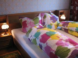 a bedroom with a bed with colorful pillows at Haus Antlinger in Reutte