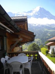 balcón con mesa, sillas y montaña en Chalet uf em Stutz 1, en Grindelwald
