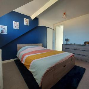 ディエップにあるl'appartement du châteauの青い壁のベッドルーム1室(大型ベッド1台付)