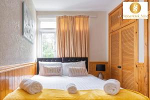 Un dormitorio con una cama con sábanas blancas y una ventana. en Sensational Stay Short Lets & Serviced Accommodation 2 bedroom Apartment Aberdeen, Middlefield Place, en Aberdeen