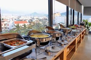 a buffet line with dishes of food on display at Arise Seaside Hotel in Nha Trang